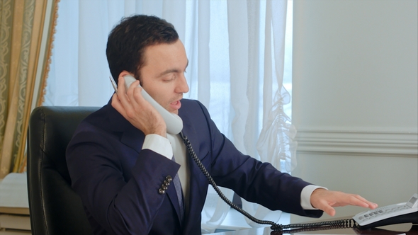 Businessman Discussing Document with Colleague on Mobile Phone