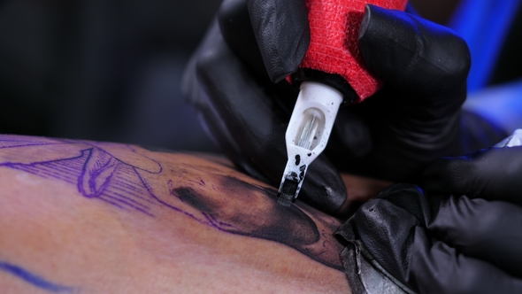 Tattoo Artist Demonstrates Process of Getting Black Tattoo with Paint and Machine