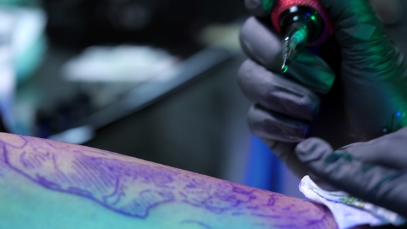 Tattoo Artist Demonstrates Process of Getting Black Tattoo with Paint and Machine