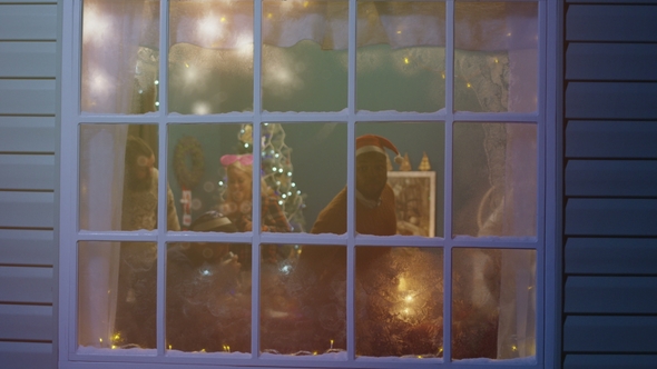 Excited Friends Looking Out in Window During Christmas