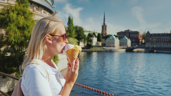 A Woman with Appetite Eats a Tasty Ice Cream on the Street of Stockholm