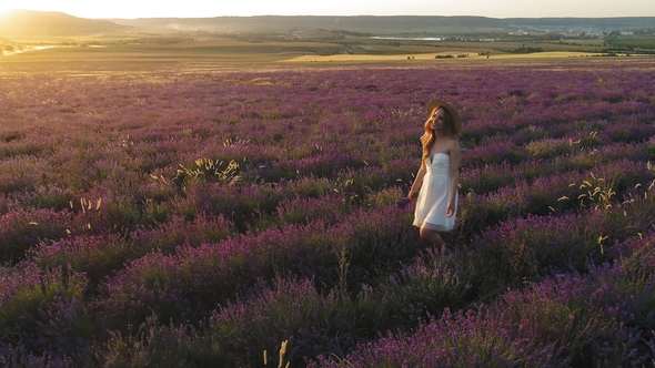 Happy Girl Walking in Lavender Field at Sunset