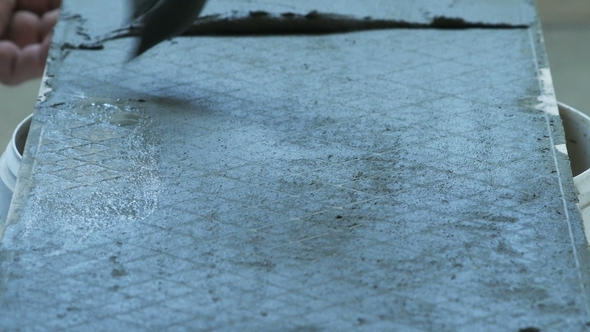 Professional Constructor Applying Cement on Floor and Laying Ceramic Tiles alt