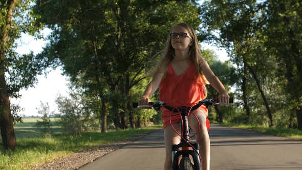 Cute Blond Teenage Girl on Bicycle Trip in Summer