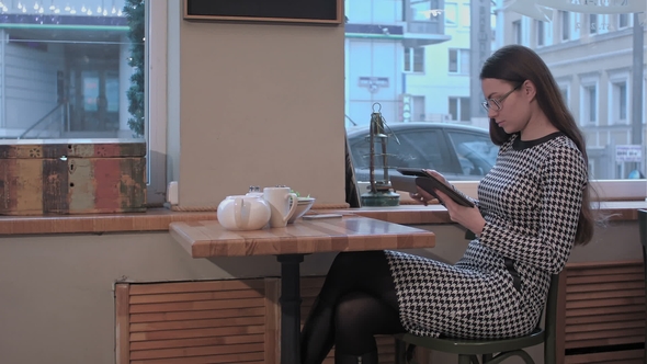 Girl in Cafe Uses Small Mobile Computer