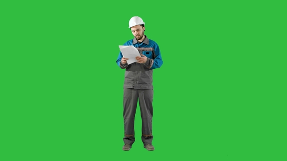 Engineer Man Verify and Read Files Documents on a Green Screen, Chroma Key