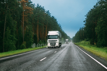  Unit In Motion On Road, Freeway. Asphalt Motorway Highway Against Background Of Forest Landscape. Business Transportation And Trucking Industry