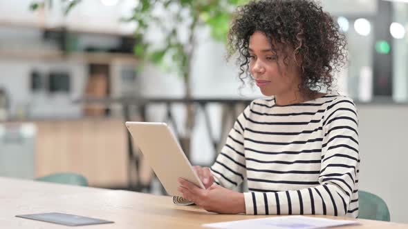 African Woman Celebrating Success on Tablet