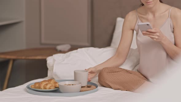 Having Breakfast and Using Smartphone in Bed