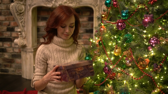 Amazed Woman Looking at Magical Christmas Gift in the Box