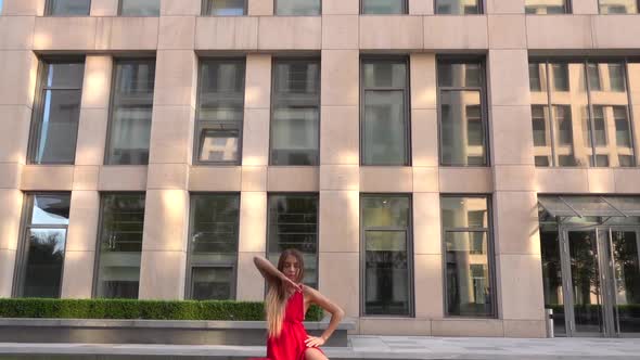 Beautiful Young Girl Dancing on the Street of a Modern City and Is Reflected in the Water. She Is