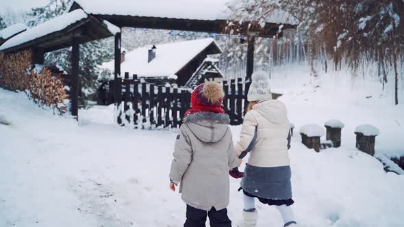 Small children coming to the wooden gate in winter