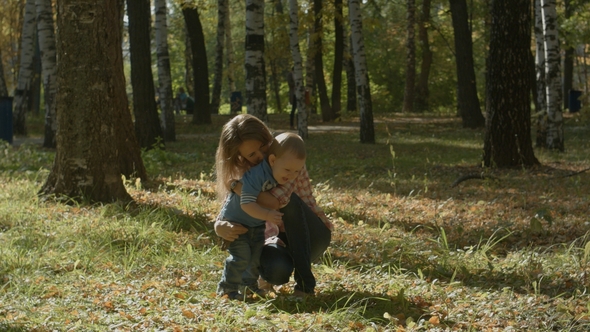 Loving Son Brings Smth To His Happy Mother and Hugs Her in Park