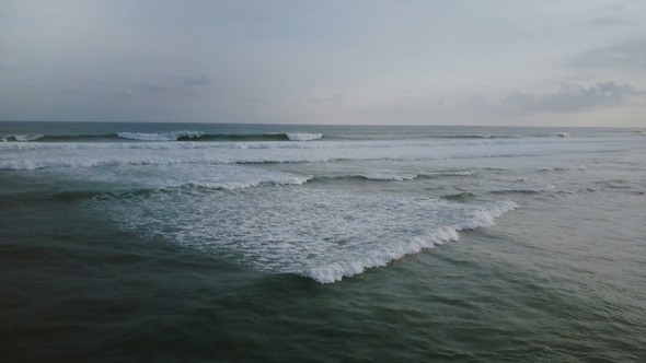 Drone Turning Left To Reveal Big Dark Blue Ocean Wave Tides Crashing with White Foam