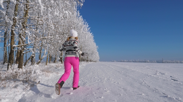 Woman Running Away Into The Distance On A Snow Covered Field On Winter Fairy Day