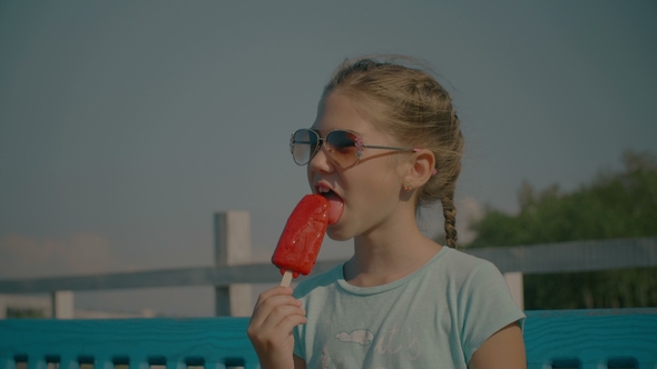 Joyful Cute Girl Eating Fruit Ice Cream in Summer