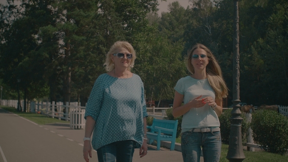 Joyful Mother and Adult Daughter Resting in Park