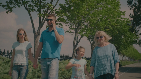 Three Generation Family Taking a Walk in Summer Park