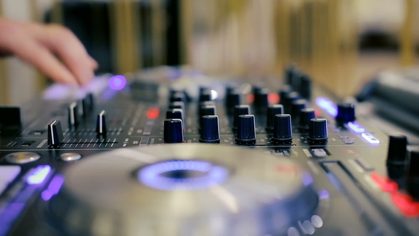 Hands of a Disc Jockey on the Professional Mixing Controller