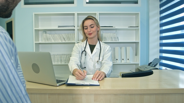 Smiling Nurse with Laptop Scheduling Appointment for Male Patient at Reception