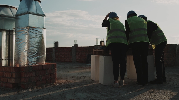 Construction Site Group of Engineers Discussing About the Building Plan alt
