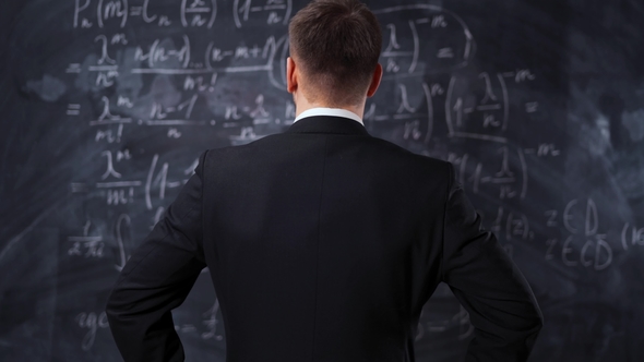 Rear View of Man Against Chalkboard with Math Formula Equations alt