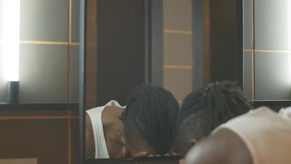 Reflection of Confident Young African American Man Washing Face in the Morning. Close-up Portrait of