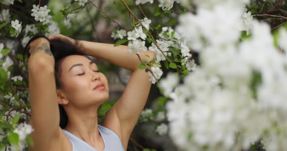 Woman Doing Yoga Pose on the Background of a Blooming Apple Tree