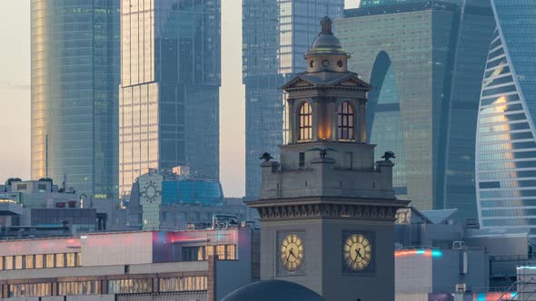 View of the clock tower of Kyiv Railway Station in Moscow in front of skyscrapers.