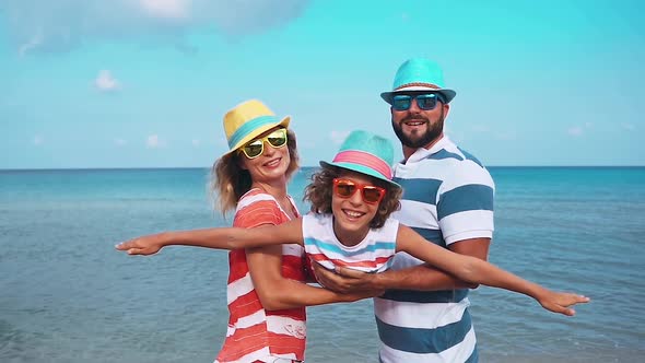 Father, Mother and Child against Blue Sea and Sky Background