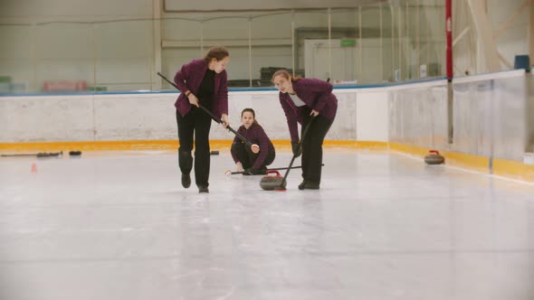 Curling - Leading Granite Stone on the Ice - Rubbing the Ice Before the Stone