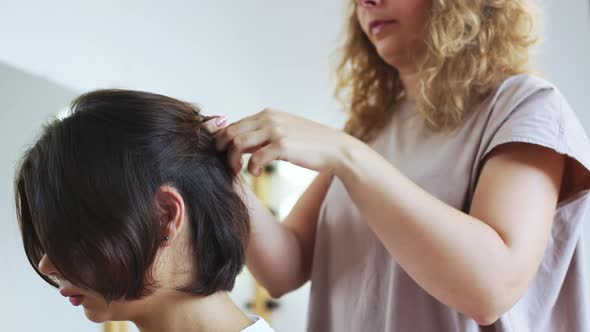 Female Hairdresser Making Hairstyle to Brunette Girl in Beauty Salon Slow Motion