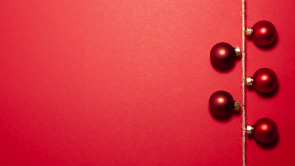 Red christmas balls on thread on the right side. Stop motion animation flat lay top view