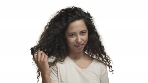 Closeup of Sassy Young Mexican Woman with Long Curly Hairstyle Seducing Someone with Sexy Look