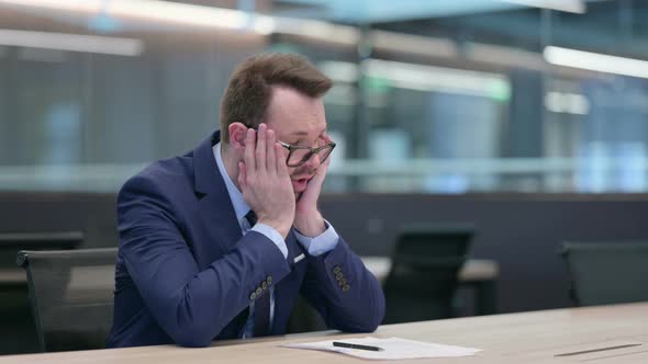 Middle Aged Businessman Reacting to Loss While Reading Documents