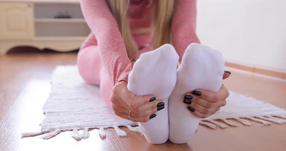 Close-up of woman in pink sportswear practicing forward bends doing yoga at home in apartment 