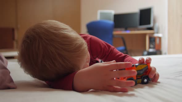 Boy On The Bed With Toy Car