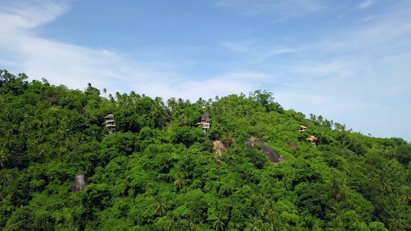 Aerial View of Private Secluded Villas on Tropical Island in Remote Location Among Green Palm Trees
