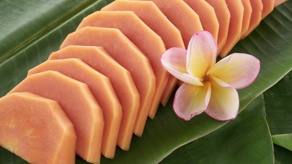 Slices of Fresh Raw Exotic Tropical Thai Fruit Carica Papaya Rotating on Banana Leaf