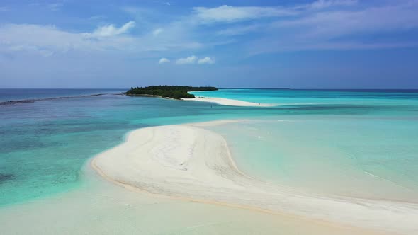 Unspoiled white sandy stripe beach washed by calm clear water of turquoise lagoon near beautiful tin