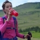 Woman Taking a Break To Drink From Water Bottle While Hiking. - VideoHive Item for Sale