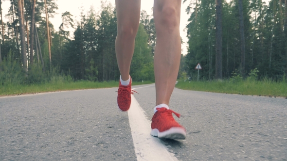 Footage of Female Legs Running Along the Alley in a Front View