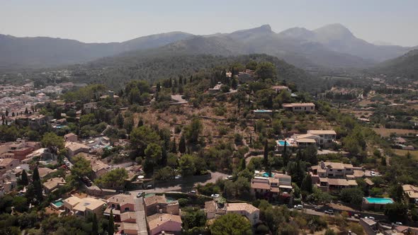 AERIAL: Flying drone backwards over mediterranean city on hills in mallorca