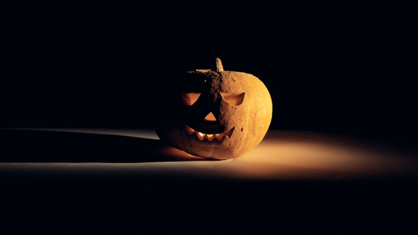 Halloween Pumpkin in Dark. The Light Goes Out Leaving a Glowing Jack-o-lantern in Complete Darkness