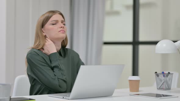 Young Woman Having Neck Pain While Typing on Laptop 