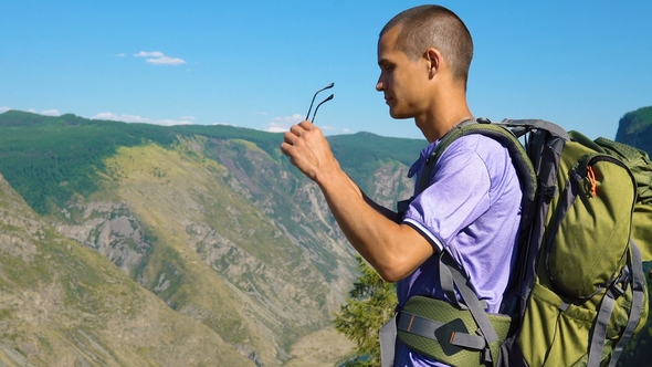 A Tourist with a Backpack in the Mountains.