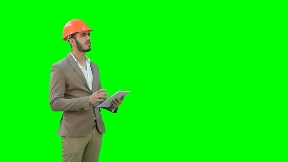 Engineer in Safety Helmet Conducting Inspection with Tablet on a Green Screen alt