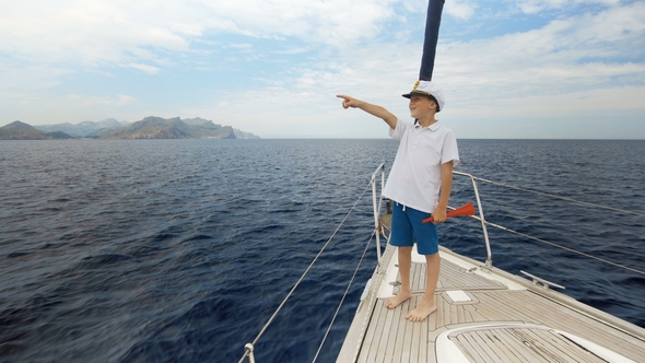 Summer Picture. A Happy Boy in a Cap Is Standing on the Yacht and Counting the Number of Yachts That