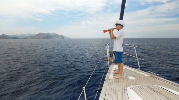 Summer Picture. A Happy Boy in a Cap Is Standing on the Yacht and Counting the Number of Yachts That