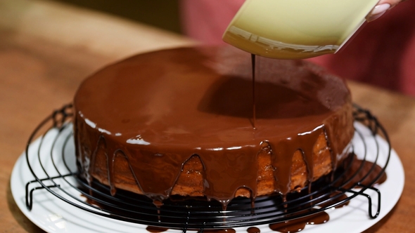 Making Sacher Cake - Traditional Austrian Chocolate Dessert. Pouring Chocolate Glaze.
